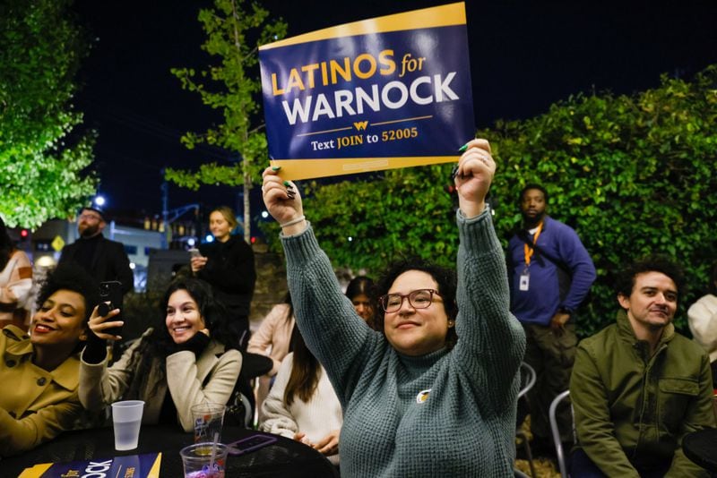 Supporters cheer for U.S. Sen. Raphael Warnock at his Latino early vote rally Wednesday in Atlanta. A new poll of Hispanic voters shows Warnock trailing Republican Herschel Walker. (Arvin Temkar / arvin.temkar@ajc.com)