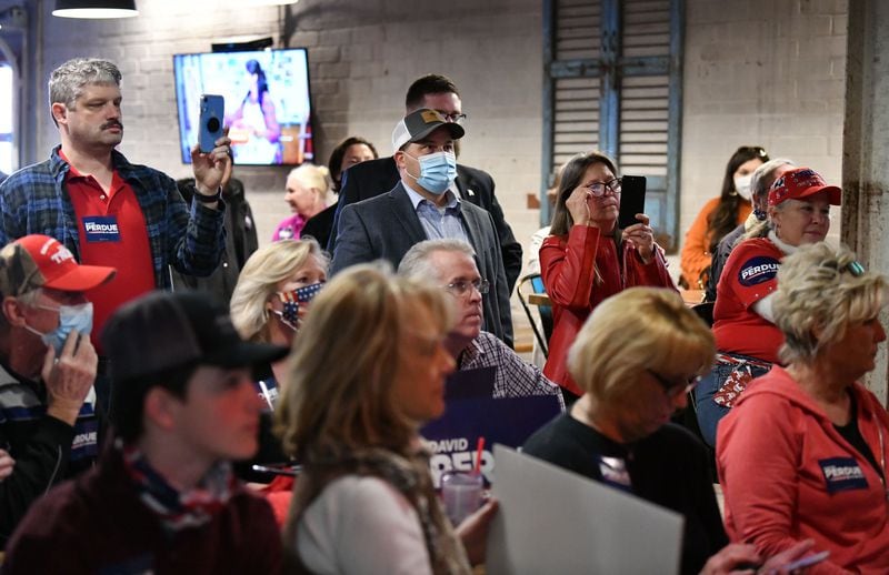 Republican state Rep. Kasey Carpenter (center, masked), for District 4, stands among supporters as U.S. Sen. David Perdue speaks during his campaign event at Cherokee Brewing + Pizza Company in downtown Dalton, Georgia on Dec. 30, 2020. (Hyosub Shin / Hyosub.Shin@ajc.com)