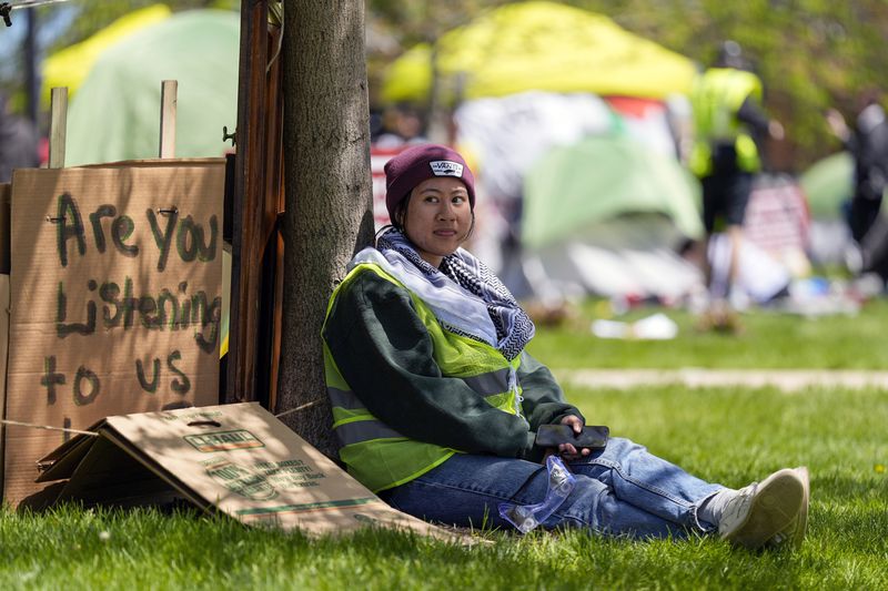 FILE - A woman sits outside an encampment area on the University of Wisconsin-Milwaukee campus, Tuesday, April 30, 2024, in Milwaukee. The Pro-Palestinian rally is calling for the University to cut ties with Israel and for peace in Gaza. (AP Photo/Morry Gash, File)