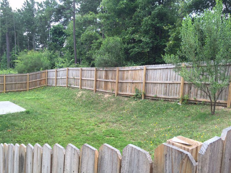 APD Solutions charged DeKalb County $10,000 to build this fence in a backyard on Piedmont Pointe Drive. JOHNNY EDWARDS / JREDWARDS@AJC.COM