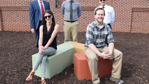 With the second of two sculptures, standing, L-R, are Geo Sipp, director of the KSU School of Art and Design; Page Birch, studio technician/coordinator, KSU School of Art and Design and Kennesaw Economic Development Director Robert Fox. Seated are KSU artists Megan Pace and Thomas Daniel. Courtesy of Kennesaw