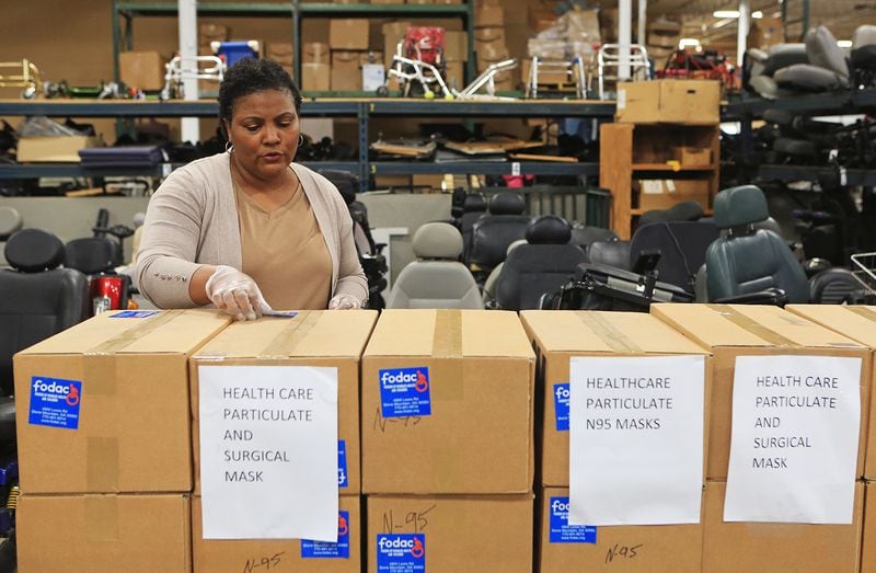 Sandra Guthrie, director of operations and administration at FODAC, puts stickers on boxes of masks and other medical supplies for delivery to Grady Hospital on Tuesday, March  24, 2020, at the FODAC warehouse in Tucker, Georgia. (Christina Matacotta, for The Atlanta Journal-Constitution)