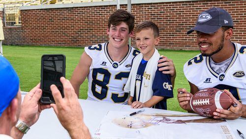 Georgia Tech wide receivers Brad Stewart (83) and Ricky Jeune (2) pose for a photo with a fan during Fan Day at Bobby Dodd Stadium on Aug. 12, 2017. -- Danny Karnik/GT Athletics