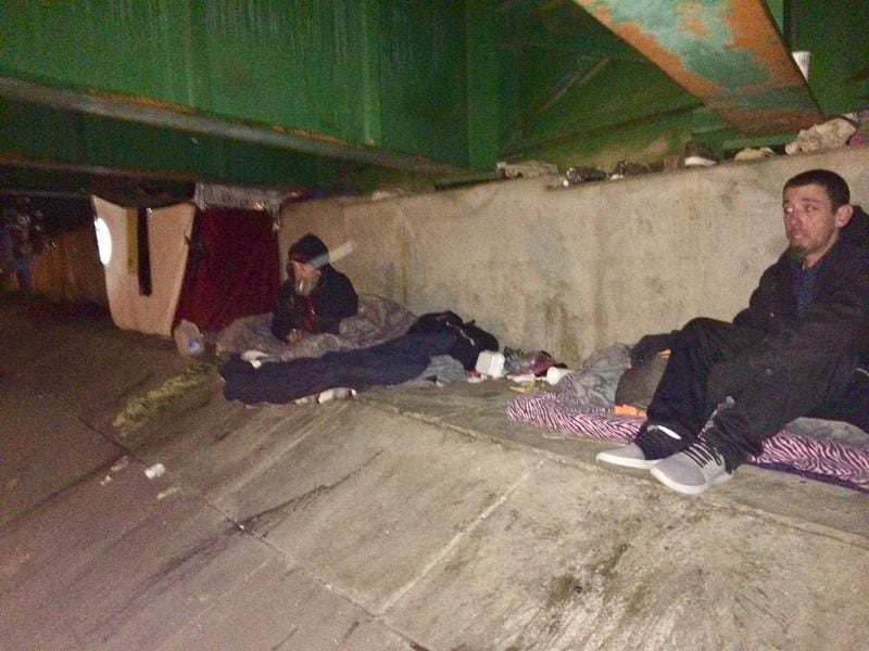 Thomas Wardham (right) sets up for the night under I-20 in Atlanta after being interviewed in the annual homeless count. 