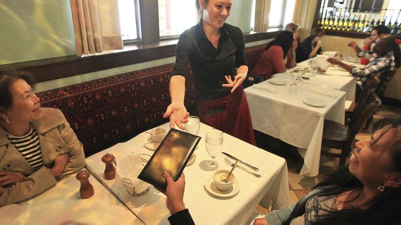 Holly Wilmarth, a server at Pasha Grill in The Greene, delivers the check to a table of customers. (Fay Traylor, left and Marylou Pugh, both from out of the area). A business professor studied 9,000 credit card receipts recently and found that diners are tipping more than 20 percent, causing people in the industry to think a 25 percent tip is the new norm. is that really gonna fly in the midwest? in new york, waiters are absolutely expecting 25 percent. we talk to restaurant association, wait staff and diners on this debate. Staff photo by Jim Witmer