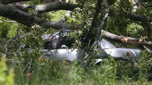 A tree fell onto power lines and a vehicle in northwest Atlanta. At least two people are inside the vehicle, an Atlanta Fire Rescue spokesman said. BEN GRAY / BGRAY@AJC.COM