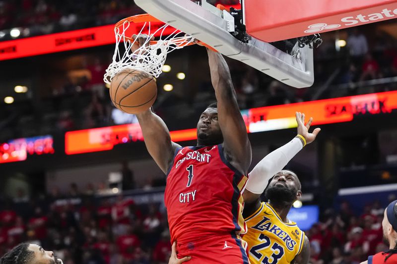New Orleans Pelicans forward Zion Williamson (1) slam dunks over Los Angeles Lakers forward LeBron James (23) in the second half of an NBA basketball play-in tournament game Tuesday, April 16, 2024, in New Orleans. The Lakers won 110-106. (AP Photo/Gerald Herbert)