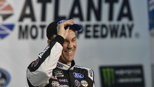 Kevin Harvick stands in Victory Lane after winning the pole for the NASCAR Monster Energy Cup auto race at Atlanta Motor Speedway in Hampton, Ga., Friday, March 3, 2017. (AP Photo/John Amis)