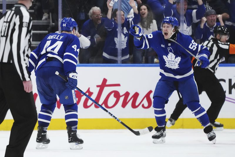 Toronto Maple Leafs' Tyler Bertuzzi celebrates his goal against the Boston Bruins with Morgan Rielly during third period of action in Game 3 of an NHL hockey Stanley Cup first-round playoff series in Toronto on Wednesday, April 24, 2024. (Nathan Denette/The Canadian Press via AP)