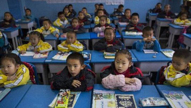 Students at a Chinese primary school in western China sit at attention at their desks. (Adam Dean/The New York Times)