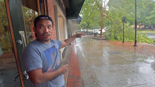 Saban Nadeak, co-owner of Samurai, a restaurant in downtown Columbus, gestures at the tree that dropped a limb on his month-old car during Tropical Storm Irma's run through the city Monday. He moved the car, which sustained little or no damage, to a parking deck.