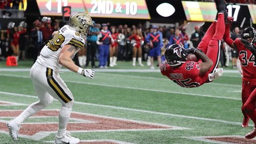 After going high to close out a victory over the Saints with an endzone interception, Falcons linebacker Deion Jones begins his descent.  (Curtis Compton/ccompton@ajc.com)