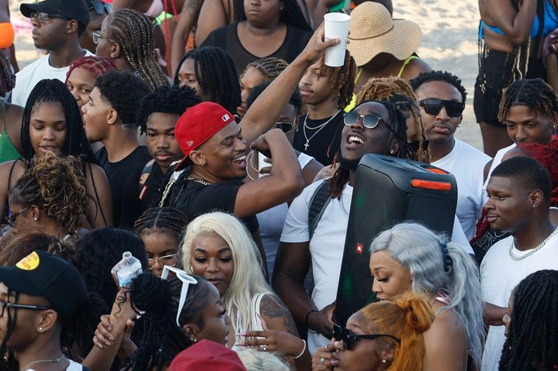 A crowd of partiers gather on the beach for Orange Crush in Tybee Island on Friday, April 19, 2024. The island put various traffic and safety protocols in place in anticipation of large crowds in town Orange Crush, an annual spring break gathering for college students. (Natrice Miller/ AJC)