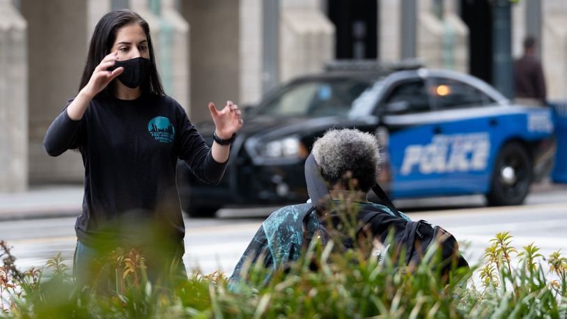 Donia Hanaei, a harm reduction specialist with the Atlanta/Fulton Pre-Arrest Diversion Initiative, talks with a person at Woodruff Park in downtown Atlanta on Wednesday, September 23, 2020. Ben Gray for the Atlanta Journal-Constitution