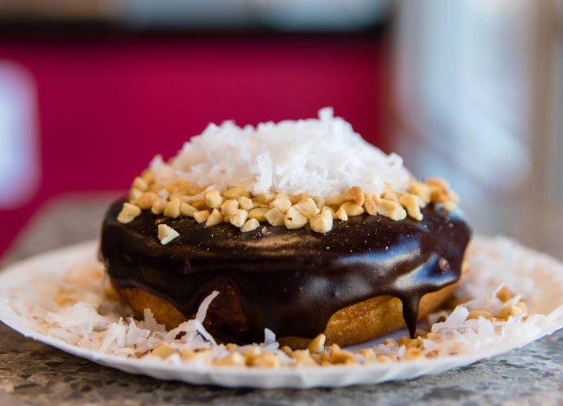 The Coconut Island Bliss doughnut at Duck Donuts includes a mountain of coconut flakes and peanut pieces. CONTRIBUTED BY HENRI HOLLIS