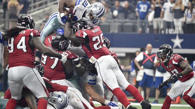 Dallas Cowboys running back Joseph Randle (21) leaps over Atlanta Falcons' Tyson Jackson (94), Grady Jarrett (97) and William Moore (25) as Ricardo Allen (37) watches for a touchdown in the first half of an NFL football game, Sunday, Sept. 27, 2015, in Arlington, Texas. (AP Photo/Michael Ainsworth)