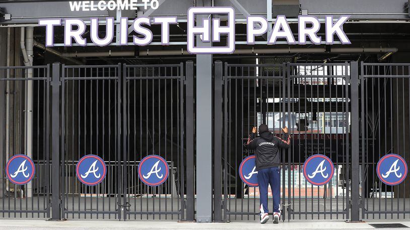 During a visit to the Battery Atlanta baseball fan Dwayne Jones pauses to take a look through the gates at the Atlanta Braves newly renamed Truist Park after new signage has been installed waiting for the delayed start of baseball season in the wake of the coronavirus on Monday, March 16, 2020.