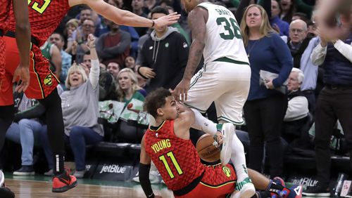 Boston Celtics guard Marcus Smart (36) steps over Hawks guard Trae Young (11), leading to a scuffle in the last seconds of an NBA basketball game Friday, Jan. 3, 2020, in Boston. The Celtics won 109-106. (AP Photo/Elise Amendola)
