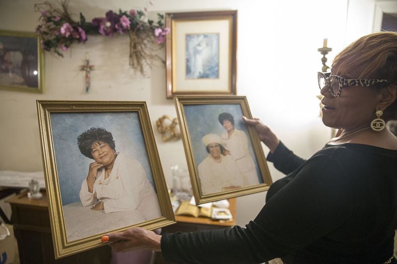 Lydia Shumake displays images of her late family members Mamie Ella Lane and Eva Greene at their residence in Stone Mountain. (Alyssa Pointer/Atlanta Journal Constitution)