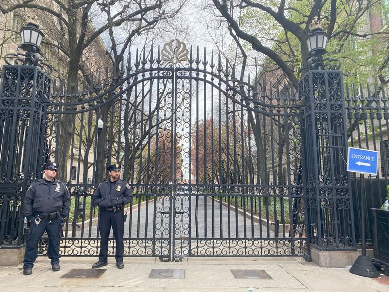 Two New York Police Department officers stand in front of the gates to Columbia University on Friday, April 19, 2024. Police last week arrested more than 100 people on campus for protests at the private university. (Alice Tecotzky for The Atlanta Journal-Constitution)