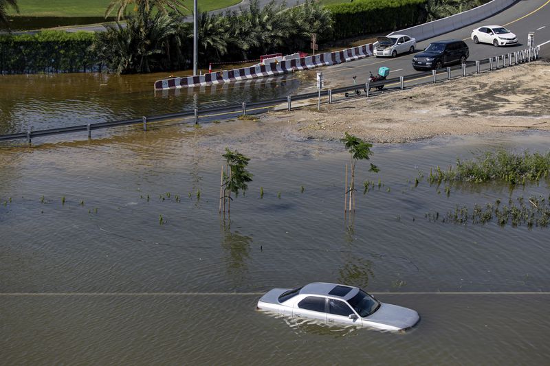 An abandoned vehicle stands in floodwater caused by heavy rain in Dubai, United Arab Emirates, Thursday, April 18, 2024. The United Arab Emirates attempted to dry out Thursday from the heaviest rain the desert nation has ever recorded, a deluge that flooded out Dubai International Airport and disrupted flights through the world's busiest airfield for international travel. (AP Photo/Christopher Pike)