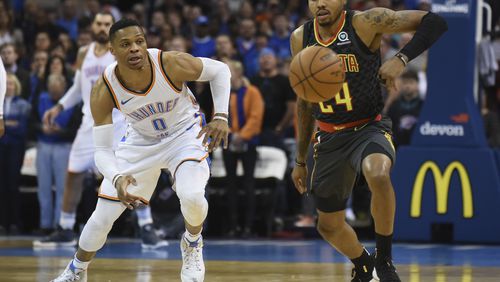 Oklahoma City Thunder's Russell Westbrook (0) tries to beat Atlanta Hawks' Kent Bazemore (24) to the ball in the first quarter of an NBA basketball game in Oklahoma City, Friday, Dec. 22, 2017. (AP Photo/Kyle Phillips)