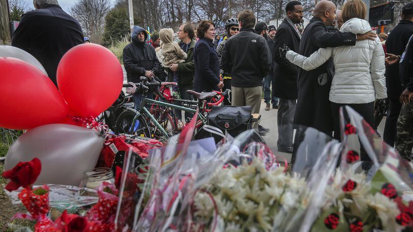A crowd gathers around the site of a memorial for a Grady High School student who was struck while riding her bicycle at 10th Street and Monroe Drive in this file photo from 2016. JOHN SPINK /JSPINK@AJC.COM