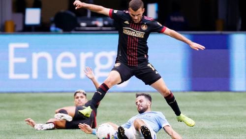 Atlanta United defender Brooks Lennon jumps as he battles for the ball against a New York City FC New York City forward Kevin O'Toole (22) during the second half at Mercedes-Benz Stadium on Sunday. Miguel Martinez / miguel.martinezjimenez@ajc.com