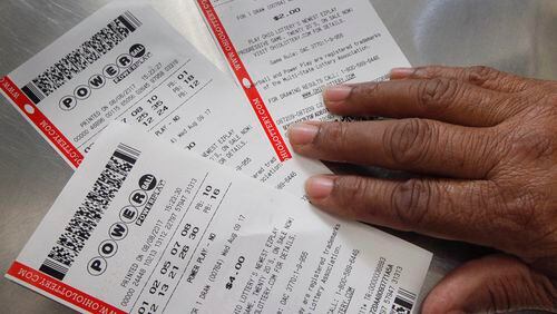 A patron at Bee Gee's Mini Market in Kettering displays their Powerball tickets for Saturday's drawing that could win someone more than $535 million. CHRIS STEWART / STAFF