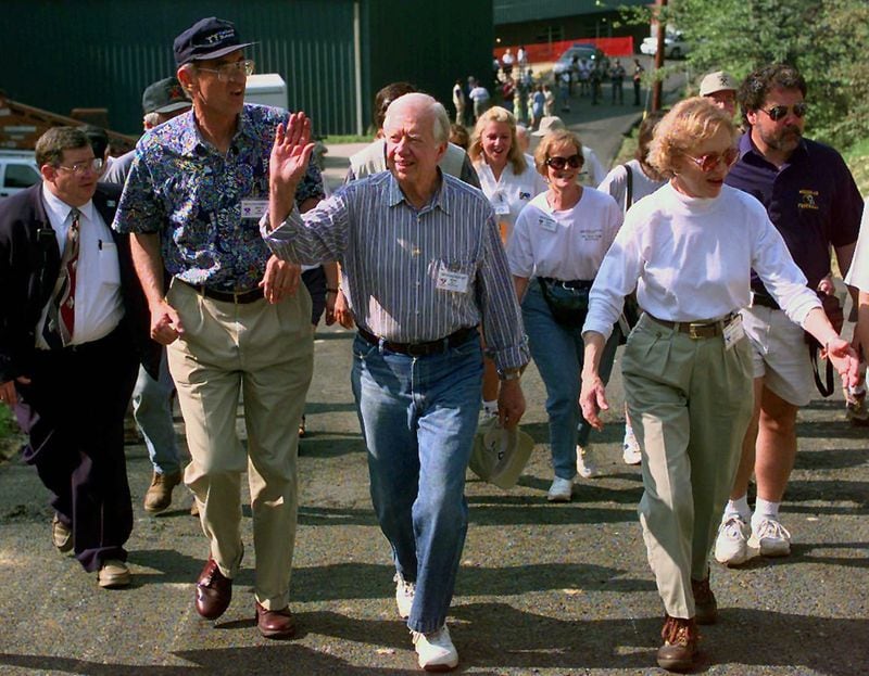 Carter, his wife Rosalynn Carter and Millard Fuller, Habitat for Humanity International founder, walk to a Habitat for Humanity building site in Pikesville, Kentucky, in 1997. (AP Photo/Ed Reinke)