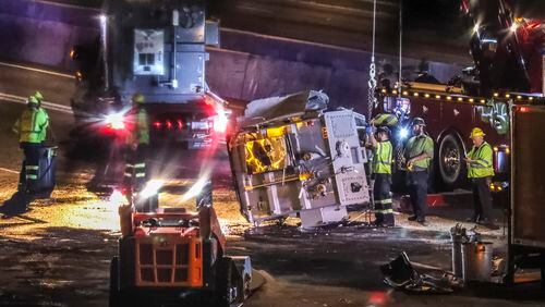 The Georgia Department of Transportation is conducting emergency repairs after a tractor-trailer overturned Tuesday morning at Spaghetti Junction. (John Spink/AJC)