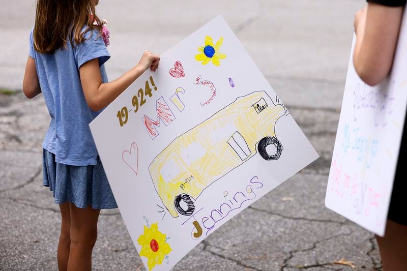Callan McCracken held a sign while waiting to surprise bus driver Alma Jennings along her bus route in Atlanta on Monday, May 23, 2022. (Natrice Miller / natrice.miller@ajc.com)