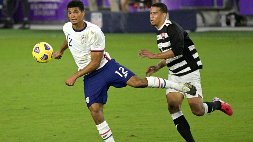 United States defender Miles Robinson (12) passes a ball in front of Trinidad and Tobago forward Ryan Telfer (7) during the second half Sunday, Jan. 31, 2021, in Orlando, Fla. Robinson, a member of the Atlanta United, started and scored in the 7-0 U.S. win. (Phelan M. Ebenhack/AP)