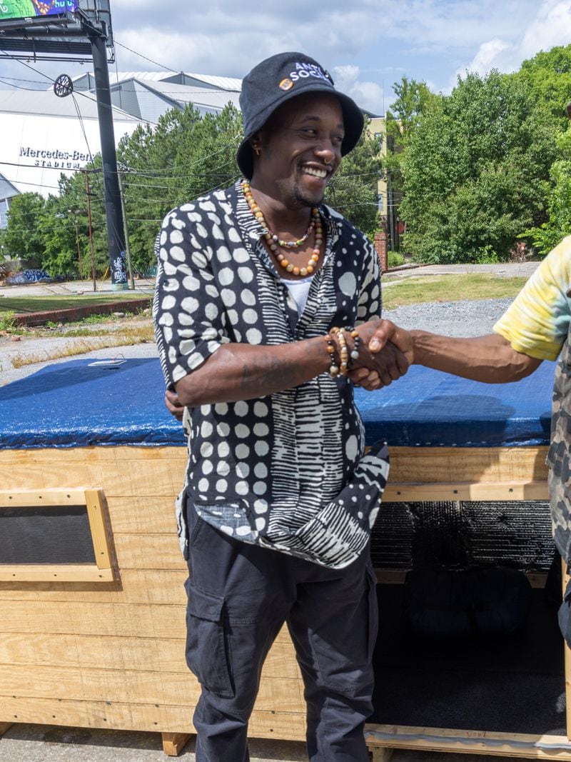 Brandon Brando (left) talks with Reginald Driskell, a homeless man living in southwest Atlanta who he befriended and constructed a 7 by 3 foot wooden structure for the man with circulating air to get him out of an old cardboard box he's been living in. He'd like to do that for others as well. 
 PHIL SKINNER FOR THE ATLANTA JOURNAL-CONSTITUTION.