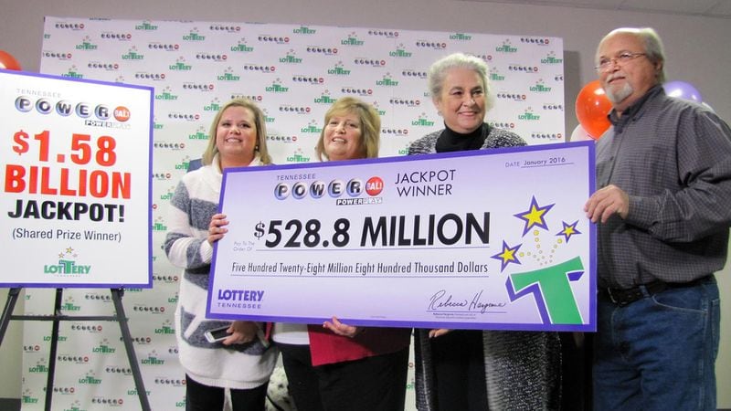 John Robinson, right; his wife, Lisa, second from the left; and their daughter, Tiffany, left, get a ceremonial check from the Tennessee Lottery on Friday, Jan. 15. 2016.