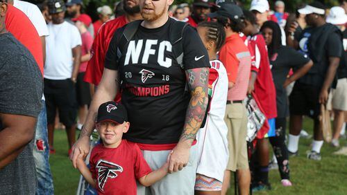 July 27, 2017 Flowery Branch: Falcons fan David Pope sports a NFC Champions shirt waiting in line with his son Samuel, 4, Woodstock, for the first day of team practice at training camp on Thursday, July 27, 2017, in Flowery Branch. Curtis Compton/ccompton@ajc.com