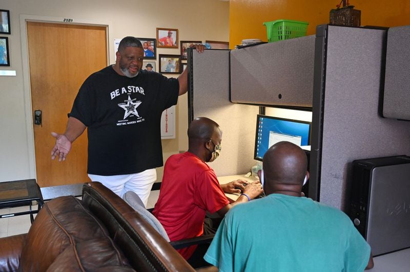 Case Manger Clyde "Ali" Wilson (left) talks to clients Craig Butler and Milton Byard as they use a computer to search job resources at Trinity Community Ministries in Atlanta. (Hyosub Shin / Hyosub.Shin@ajc.com)