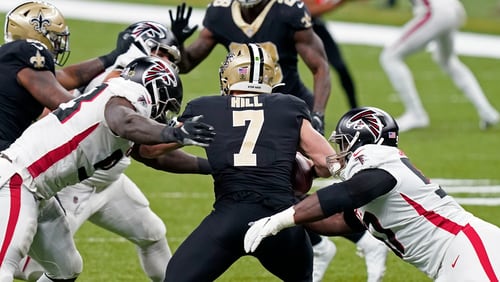 New Orleans Saints quarterback Taysom Hill (7) is sacked by Atlanta Falcons defensive end Allen Bailey, left, and defensive tackle Grady Jarrett in the first half of an NFL football game in New Orleans, Sunday, Nov. 22, 2020. (AP Photo/Butch Dill)