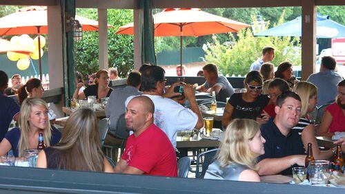 People enjoying themselves outside on the Big Ketch Saltwater Grill's patio.