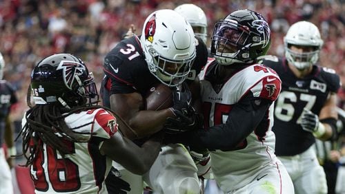 Cardinals running back David Johnson carries the ball against Falcons defensive back Kemal Ishmael and linebacker Deion Jones in the first half Oct. 13, 2019, at State Farm Stadium in Glendale, Ariz.