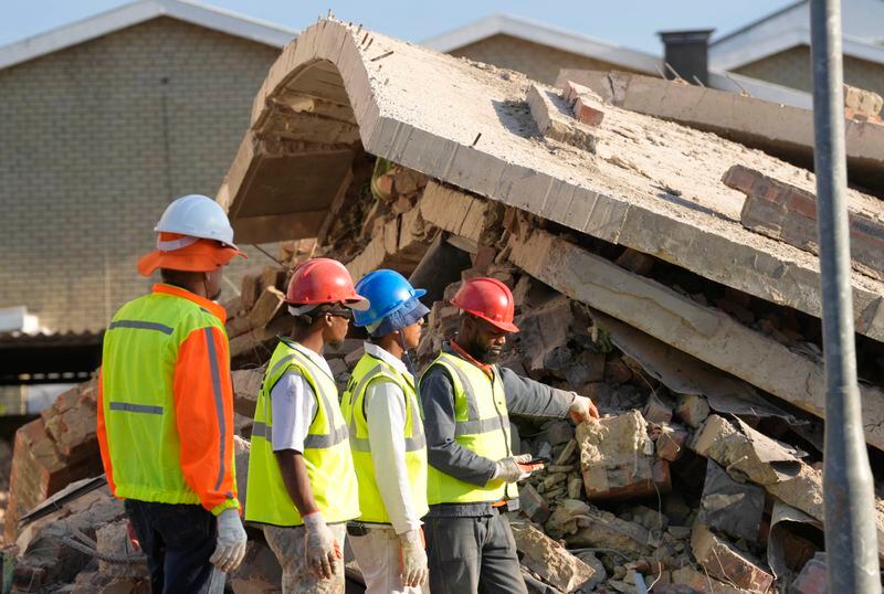 Emergency workers on the scene of a building collapse in George, South Africa, Tuesday, May 7, 2024. 5 workers have been killed with 49 still trapped after the building under construction collapsed Monday. (AP Photo/Nardus Engelbrecht)