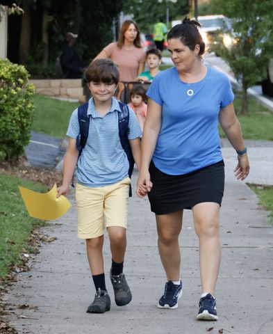 Ashley and fifth grader Sam Pollet walk to school for the first day of school at Springdale Park Elementary School in Atlanta on Tuesday, August 1, 2023.   (Bob Andres for the Atlanta Journal Constitution)