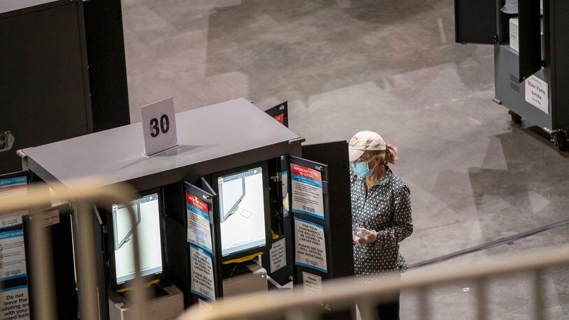10/15/2020 - Atlanta, Georgia -  Fulton County residents use electronic voting machines to cast their ballotst on the floor of State Farm Arena during the fourth day of early voting in Georgia, Thursday, October 15, 2020.  (Alyssa Pointer / Alyssa.Pointer@ajc.com)