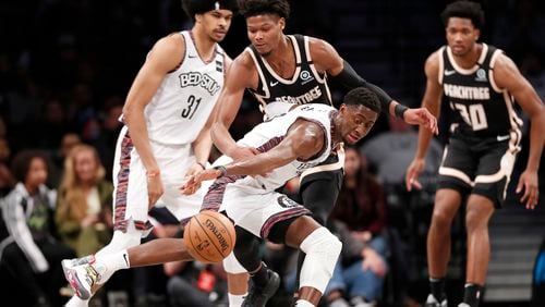 Atlanta Hawks forward Cam Reddish (center, rear) watches as Brooklyn Nets guard Caris LeVert (22) loses control of the ball during the first half Sunday, Jan. 12, 2020, in New York.