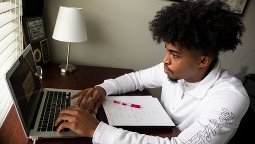 Cole Brown, a senior at South Gwinnett High School, checks through his assignments during Advanced Placement literature class on Thursday, April, 29, 2021 in his bedroom in Loganville.  Ben Gray for the Atlanta Journal-Constitution