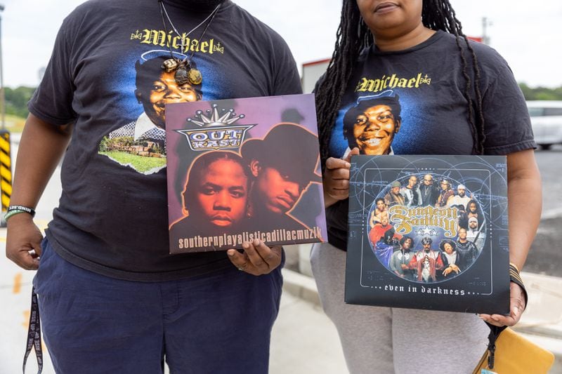 Mourners watching the funeral procession of hip-hop pioneer Rico Wade carry records at the intersection of Headland and Delowe, an East Point hip-hop landmark, on Friday, April 26, 2024. (Arvin Temkar / AJC)