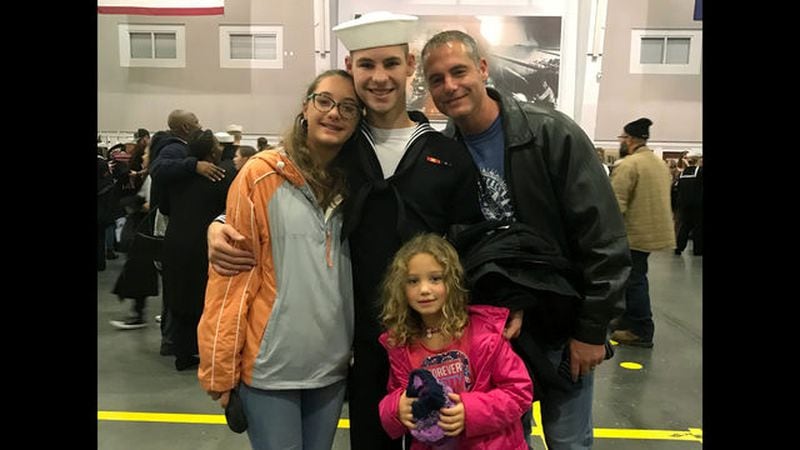 In this Nov. 22, 2019 photo provided by the Walters family, Cameron Walters, center in Navy uniform, poses for a photo with his sisters, Lily Walters, left, and Shania Walters, right, and his father, Shane Walters, far right. 