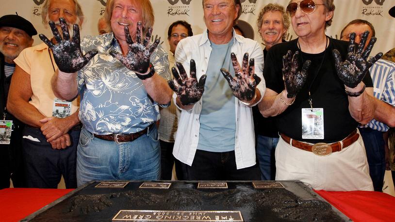 Don Randi, left, Glen Campbell, center, and Hal Blaine, representing session musicians known as The Wrecking Crew, hold up their hands after placing them in the cement following the induction ceremony for Hollywood's RockWalk in Los Angeles, Wednesday June 25, 2008. (AP Photo/Kevork Djansezian)