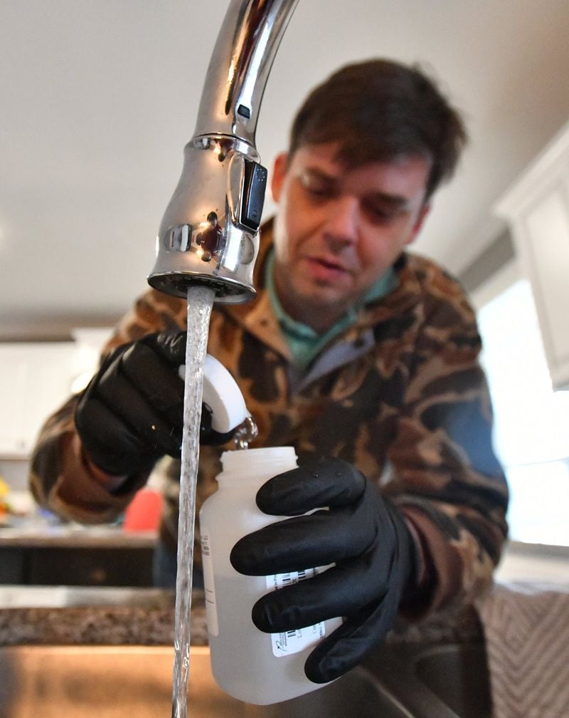 Fletcher Sams, executive director at Altamaha Riverkeeper, collects water samples for testing at Kyle Benton’s home in Forsyth, a few miles away from Georgia Power’s coal-fired power plant in Juliette. The Riverkeeper has been testing residents’ water for about a year. Some tests have revealed elevated levels of hexavalent chromium, the carcinogenic compound made famous by Erin Brockovich. HYOSUB SHIN / HYOSUB.SHIN@AJC.COM