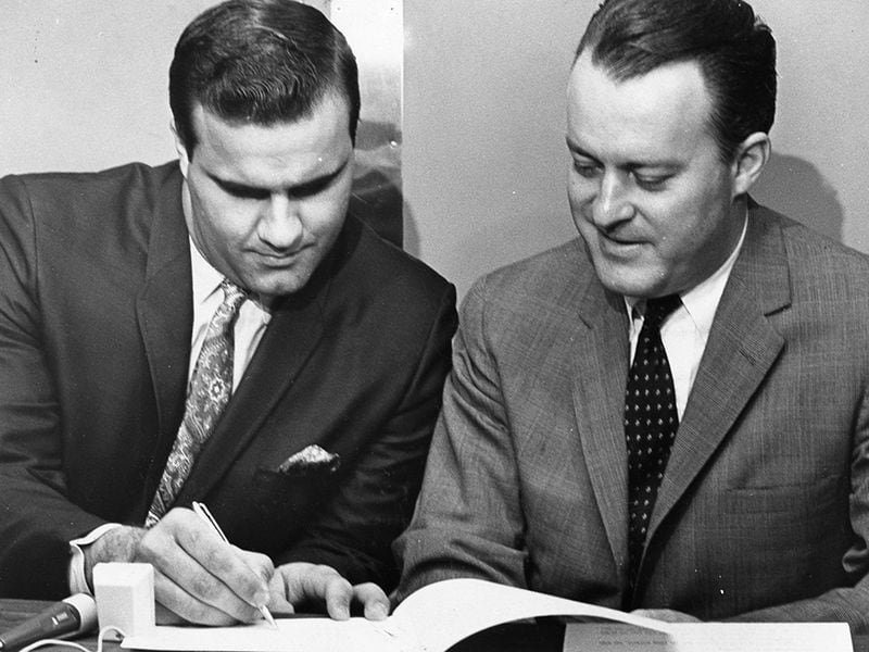 Braves owner Bill Bartholomay, right, watches catcher Joe Torre sign a new contract in 1967, signed Joe Torre to a new contract. The eventual Hall of Fame manager became the highest paid catcher in baseball at the time at $65,000 a year.